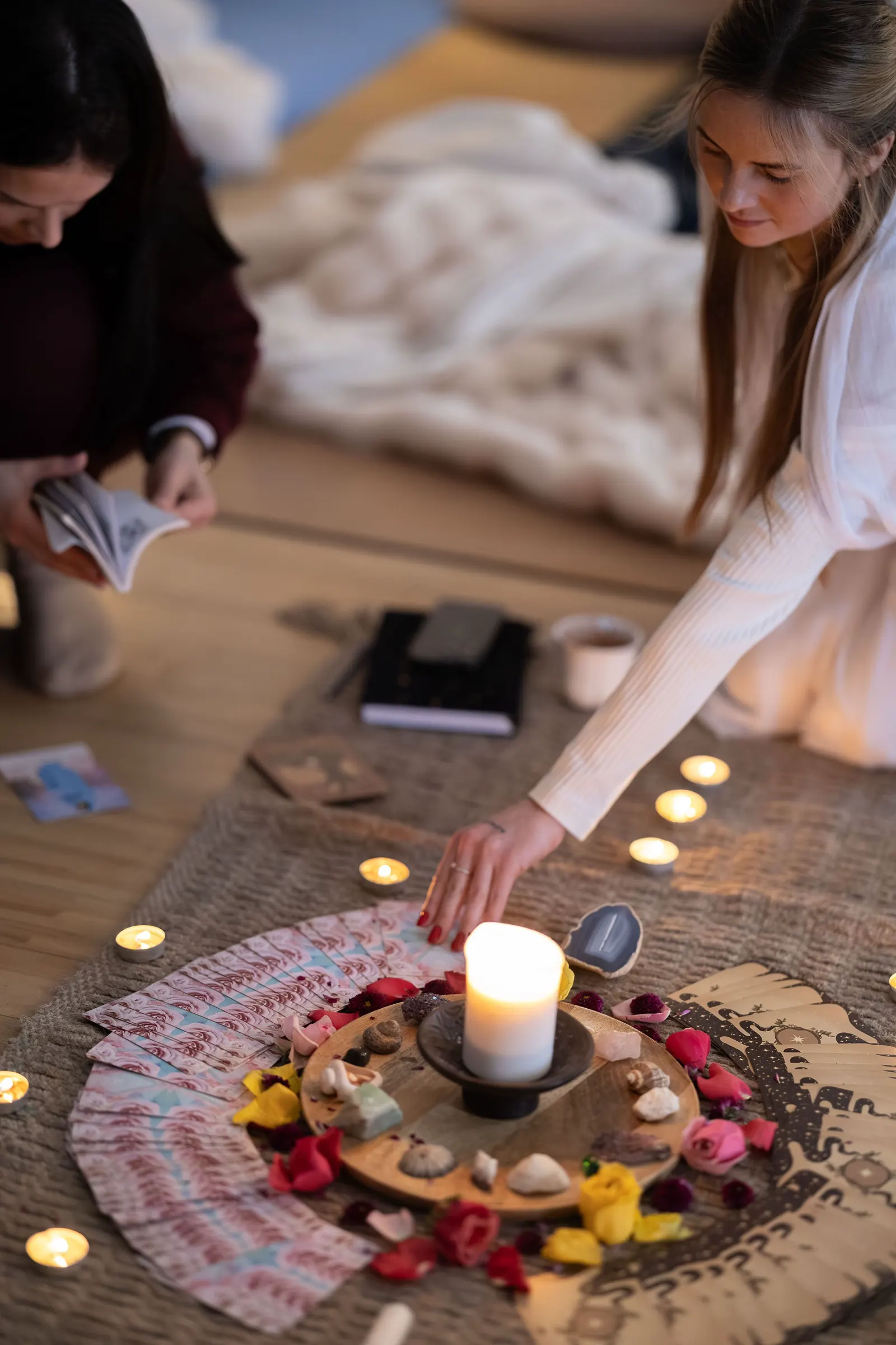 Women gathering around candles, flowers, and oracle cards.