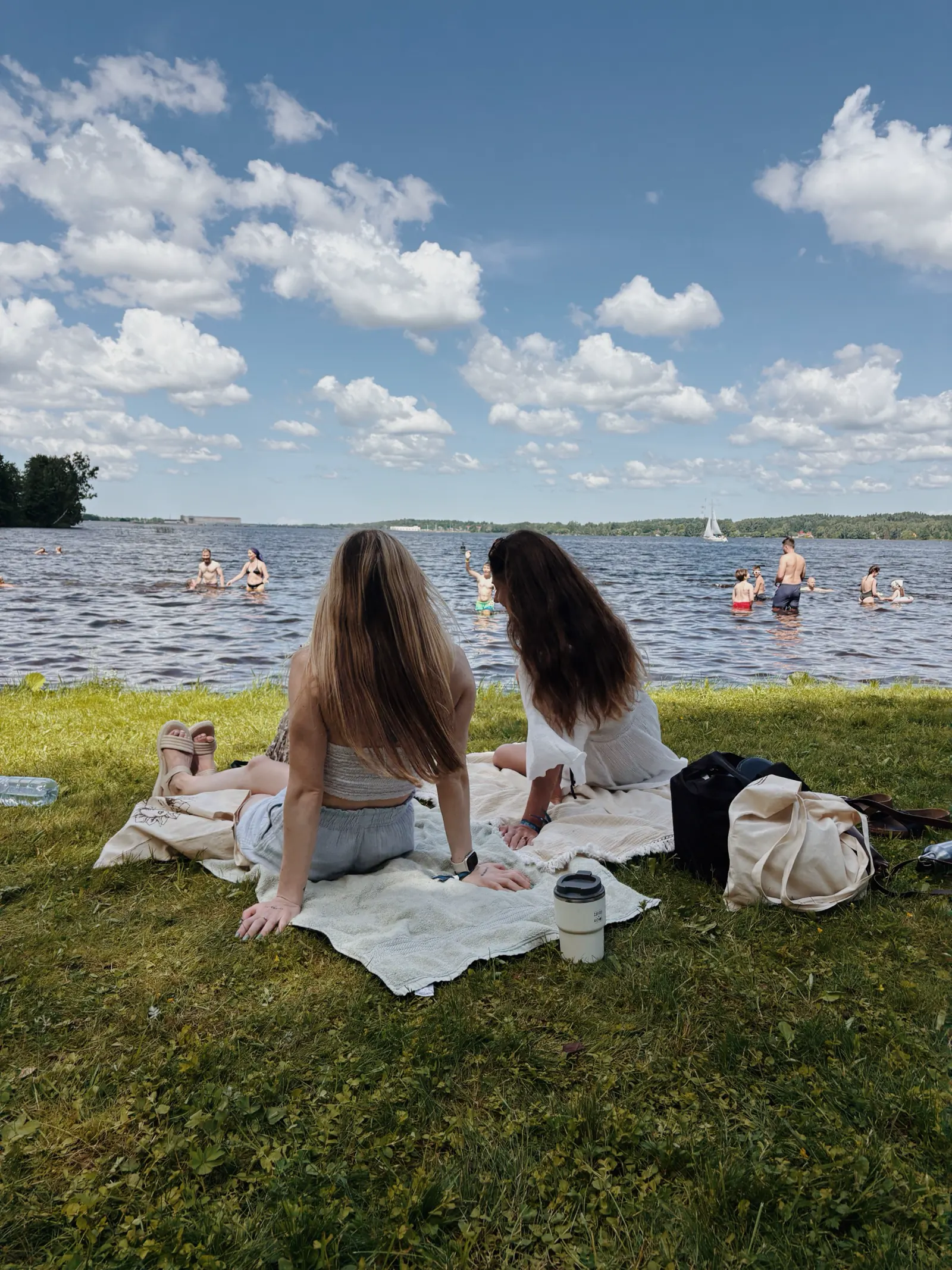 Two women resting beside the water.
